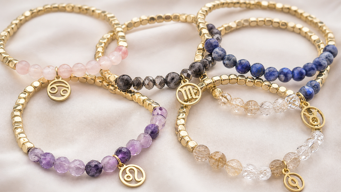 Overlapping gold bracelets with rose quartz, smoky quartz, amethyst, blue stone, clear quartz, and zodiac charms