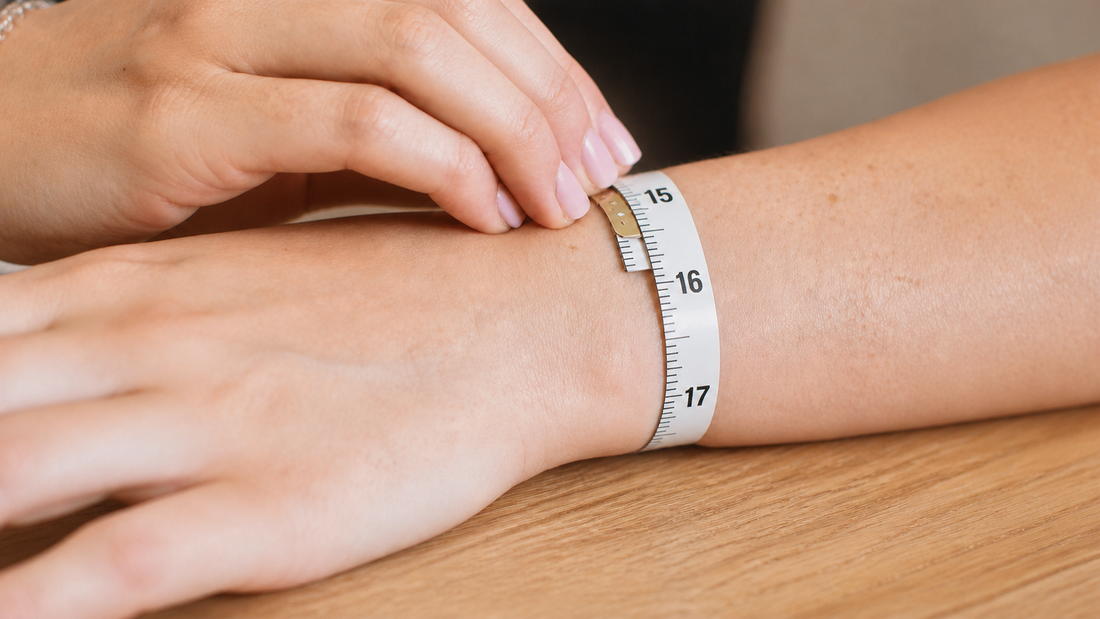 Hands measuring a relaxed wrist with a flexible centimeter tape on a wooden surface